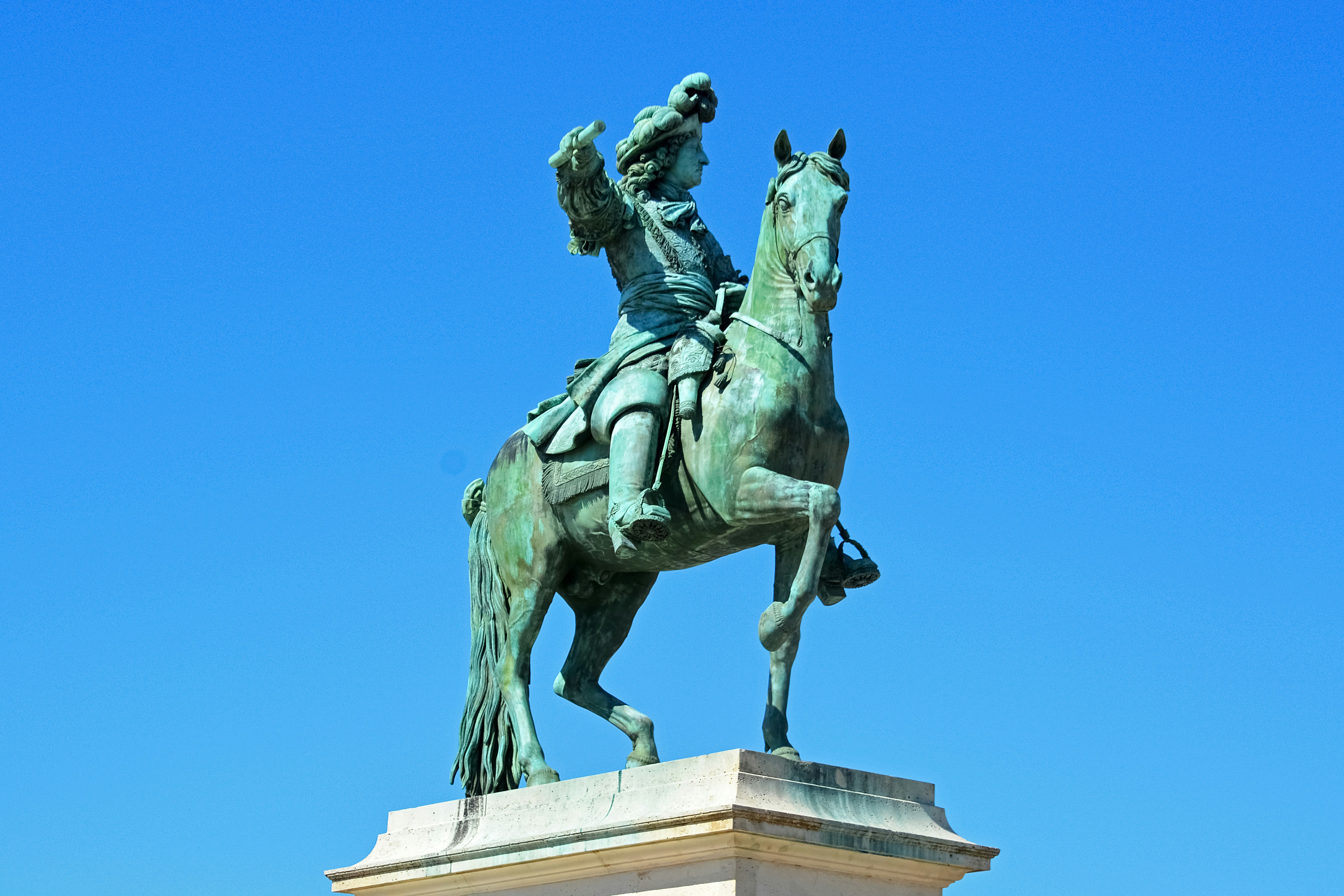 man riding horse statue under blue sky during daytime